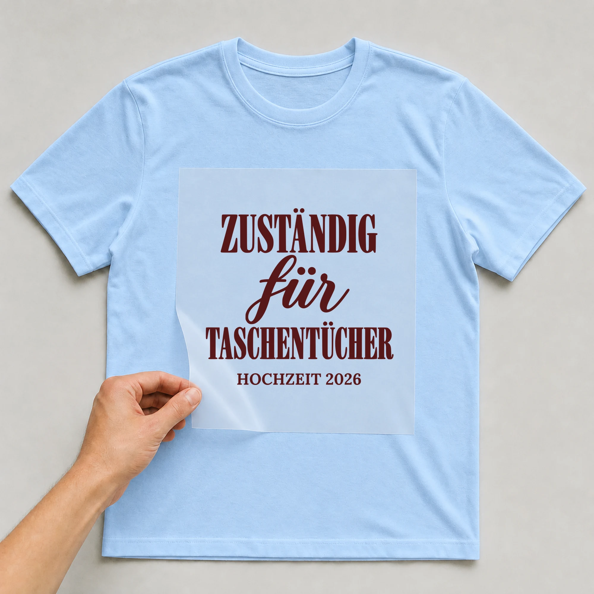 Bügelbild Zuständig für Taschentücher mit Jahr auf hellblauem T-Shirt, Folie wird aufgelegt