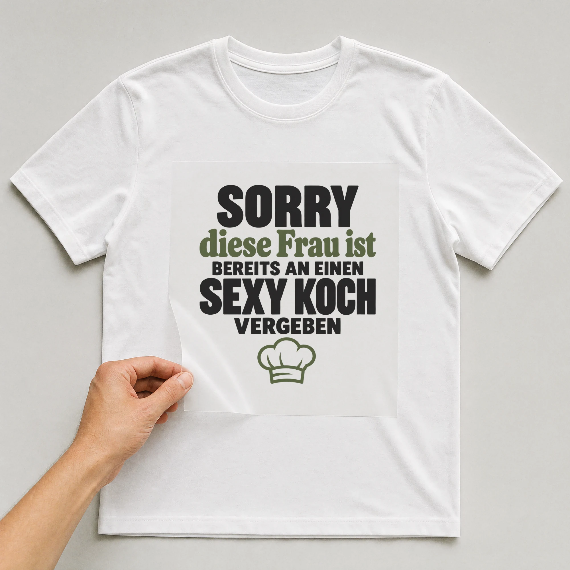Bügelbild „Sorry diese Frau ist bereits an einen sexy Koch vergeben“ auf weißem T-Shirt, Folie wird aufgelegt