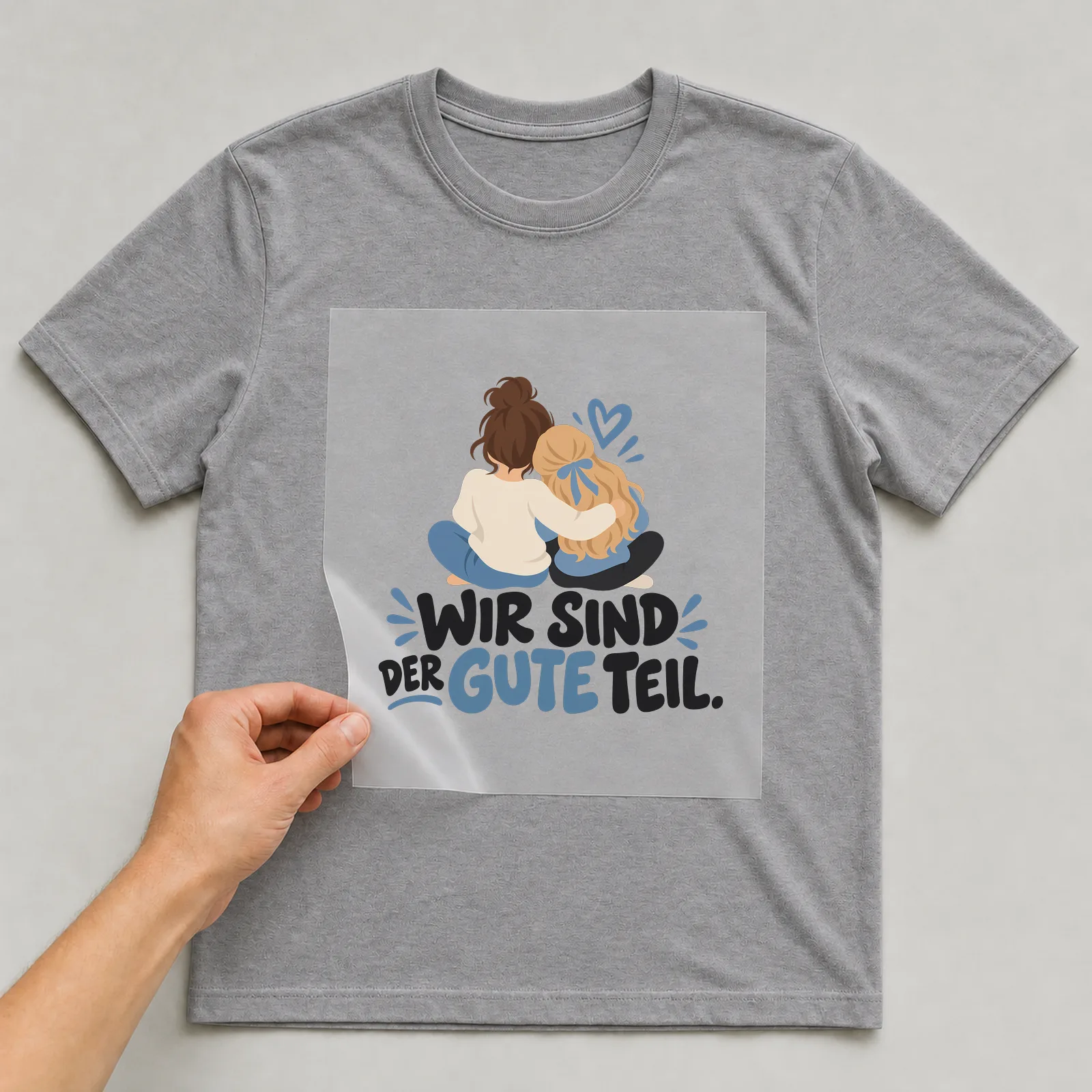 Bügelbild „Wir sind der gute teil“ auf grauem T-Shirt, Folie wird aufgelegt