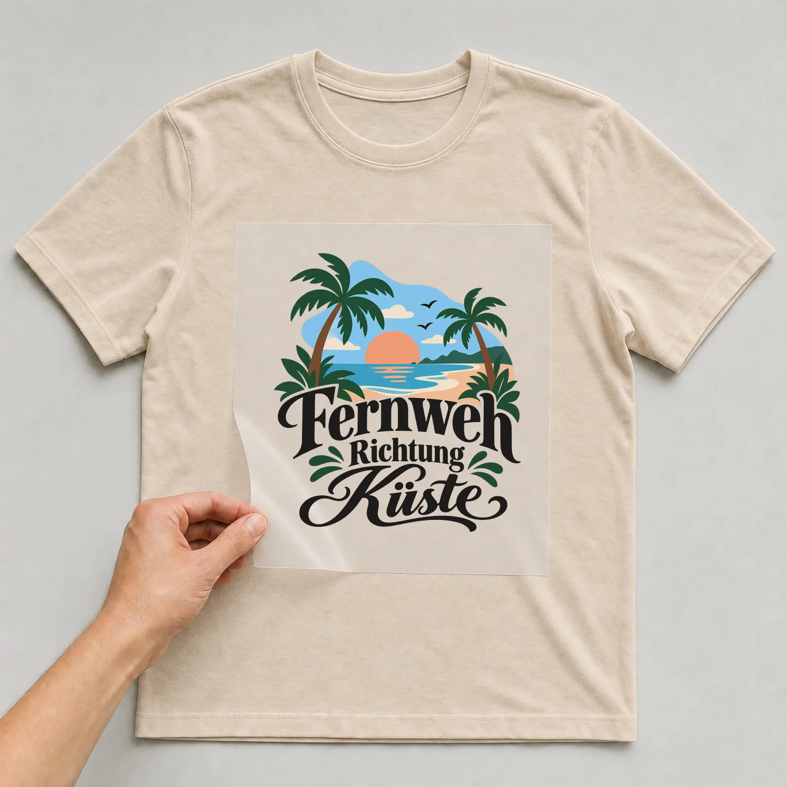Bügelbild „Fernweh Richtung Küste“ auf beigem T-Shirt, Folie wird aufgelegt