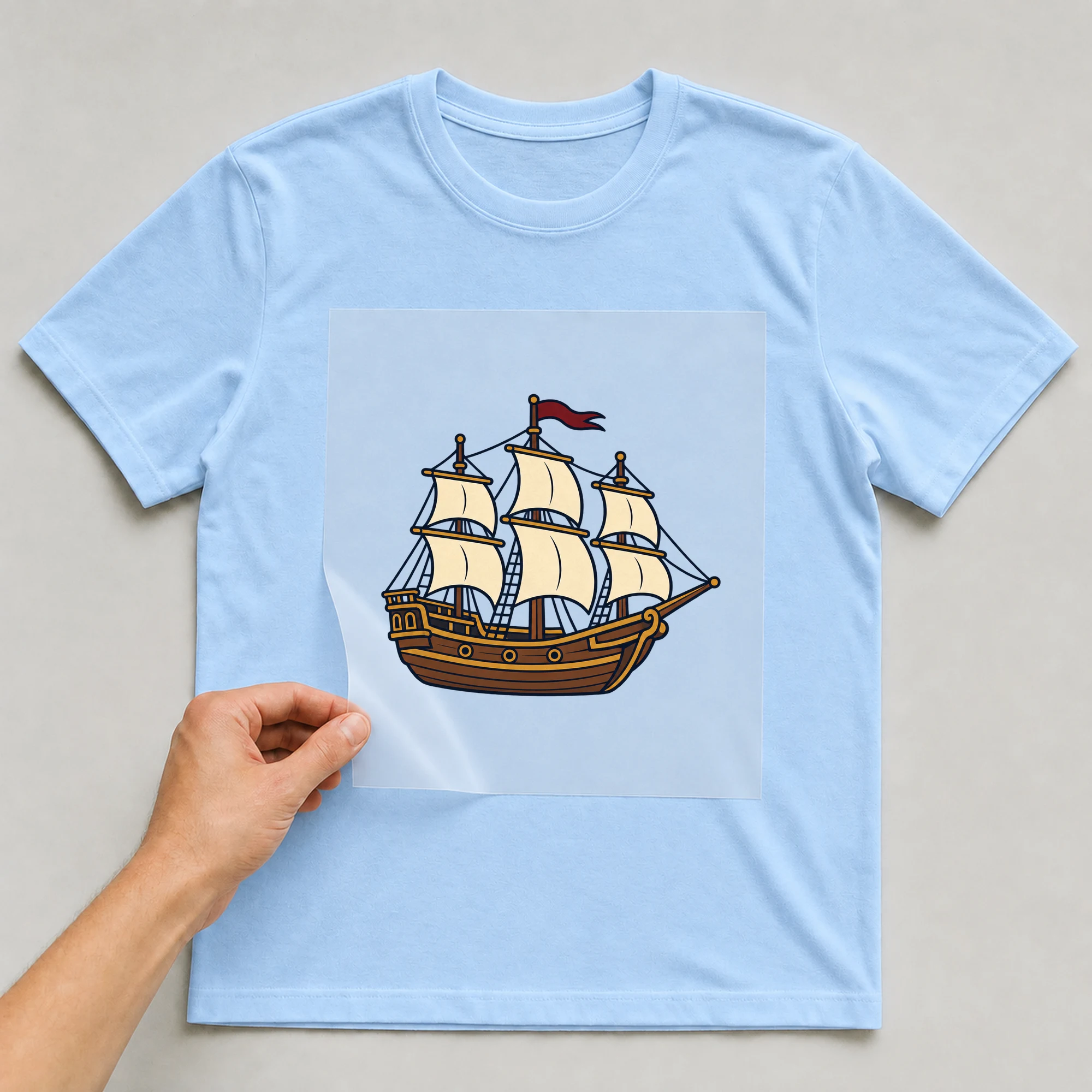 Bügelbild „BB021116-motiv-r03595“ auf babyblauem T-Shirt, Folie wird aufgelegt