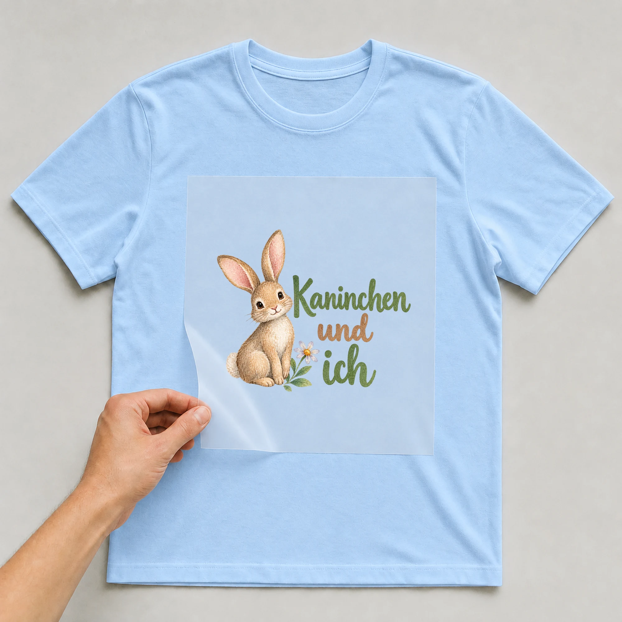 Bügelbild „Kaninchen und ich“ auf babyblauem T-Shirt, Folie wird aufgelegt