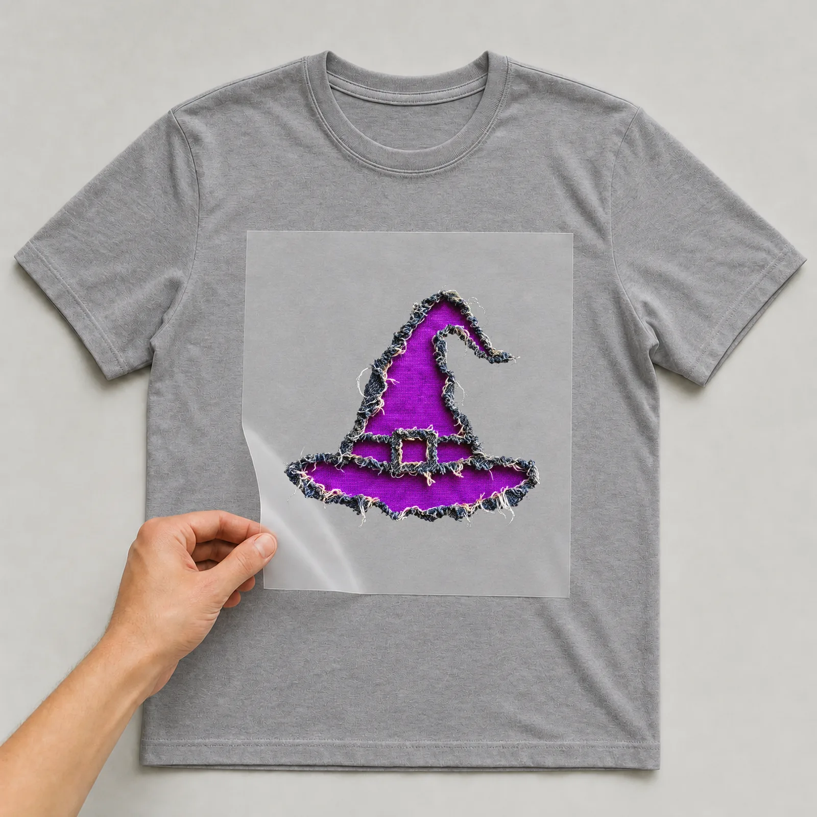 Bügelbild Hexenhut Zerrissen (Halloween) auf grauem T-Shirt, Folie wird aufgelegt