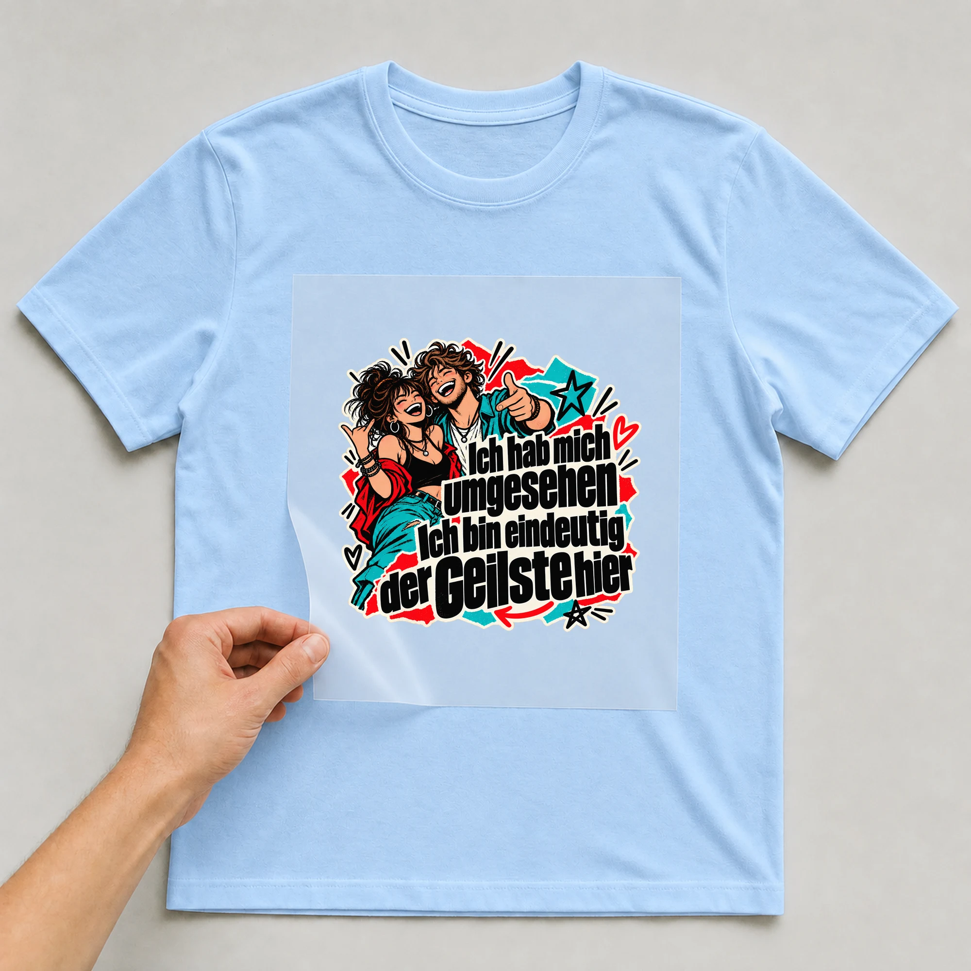 Bügelbild „Ich bin eindeutig der Geilste hier“ auf babyblauem T-Shirt, Folie wird aufgelegt
