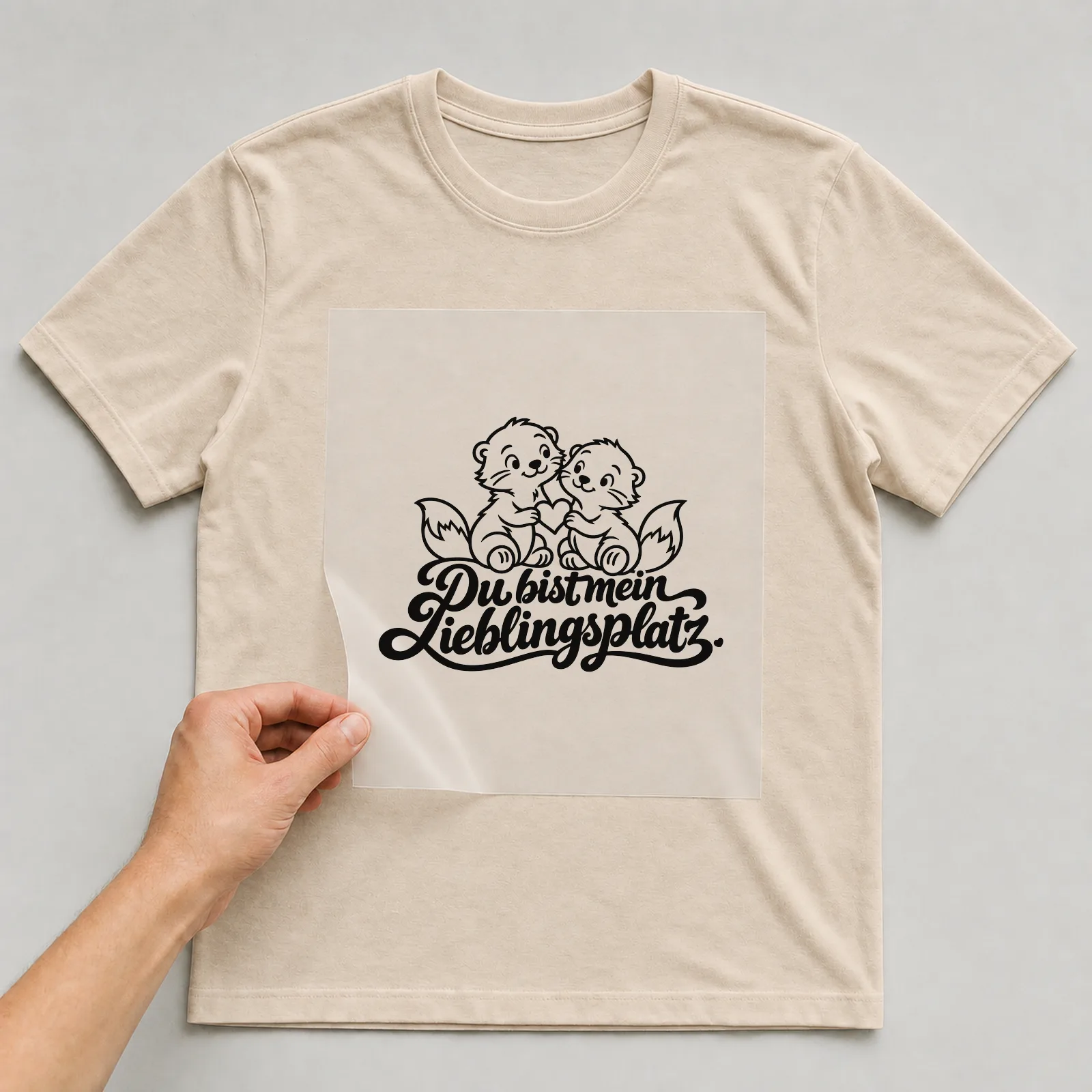 Bügelbild „Du bist mein Lieblingsplatz“ (klaren Konturen) auf beigem T-Shirt, Folie wird aufgelegt