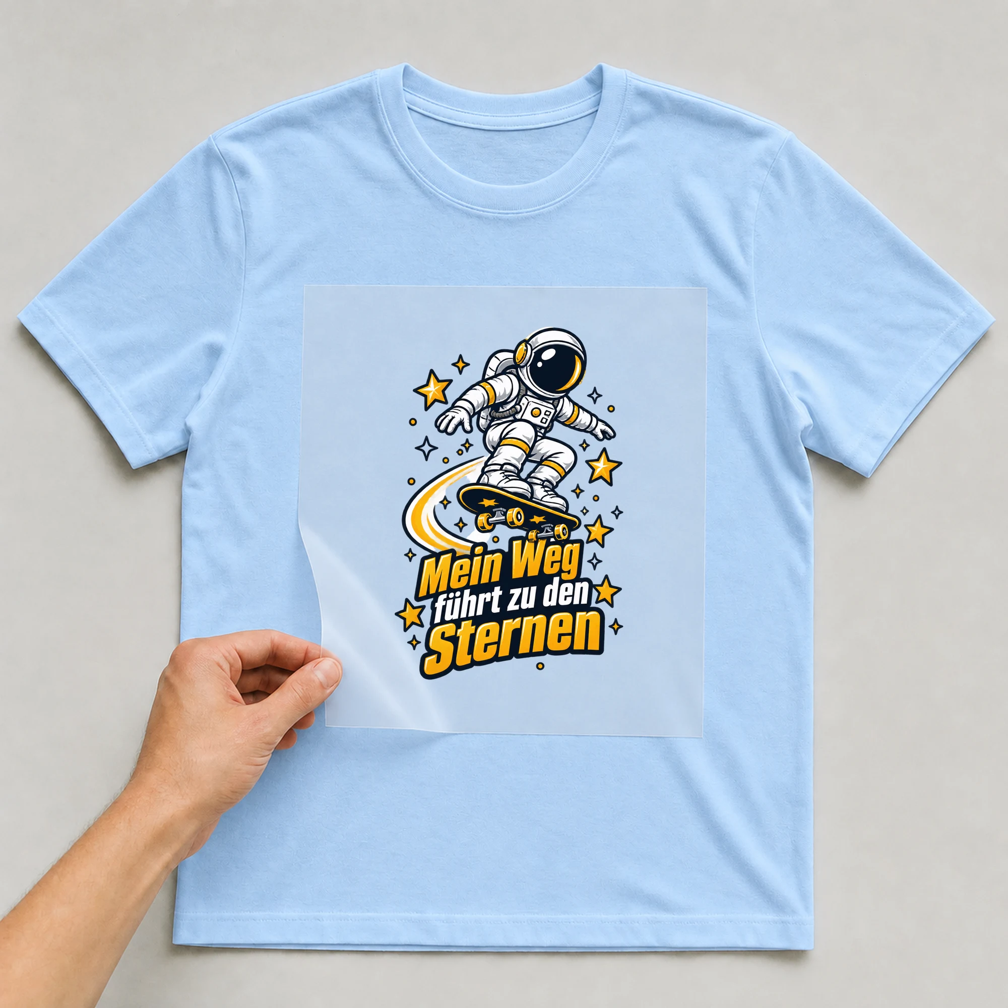 Bügelbild „Mein weg hat Sternenrollen“ auf babyblauem T-Shirt, Folie wird aufgelegt