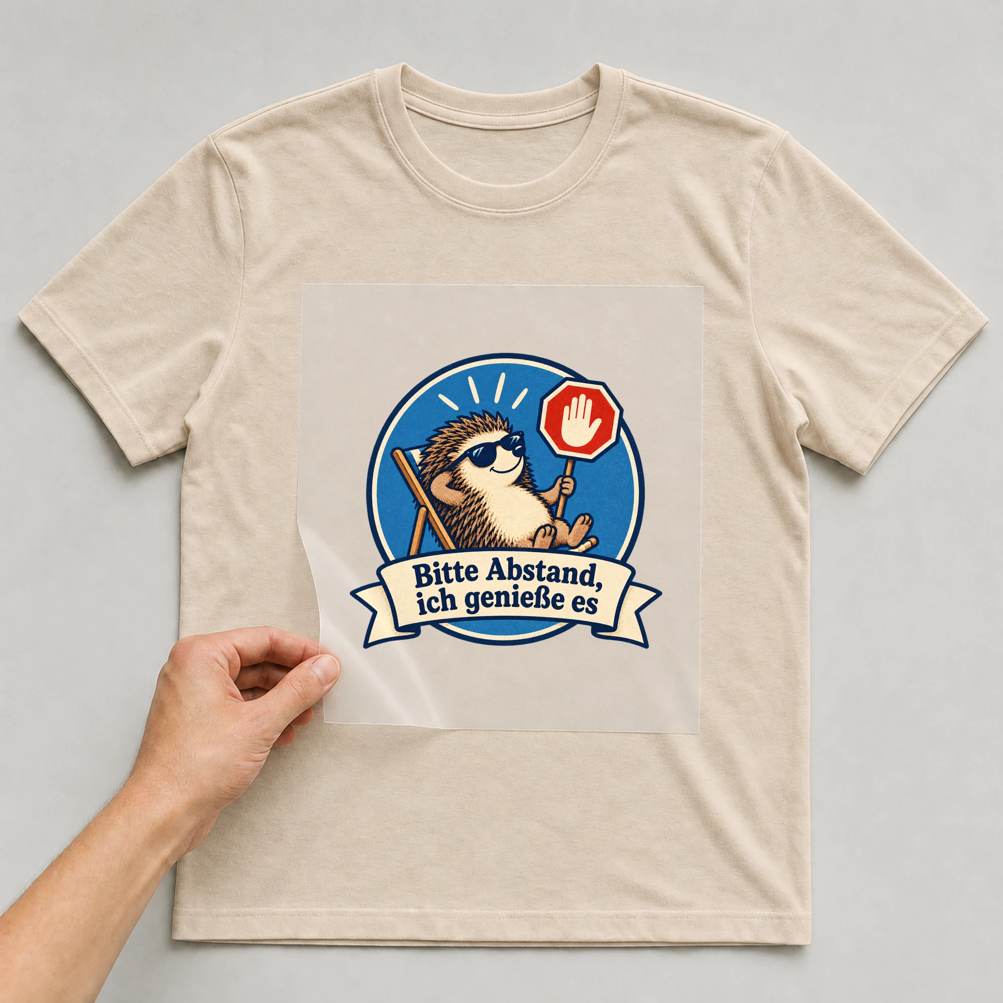 Bügelbild „Bitte Abstand ich genieße es“ auf beigem T-Shirt, Folie wird aufgelegt