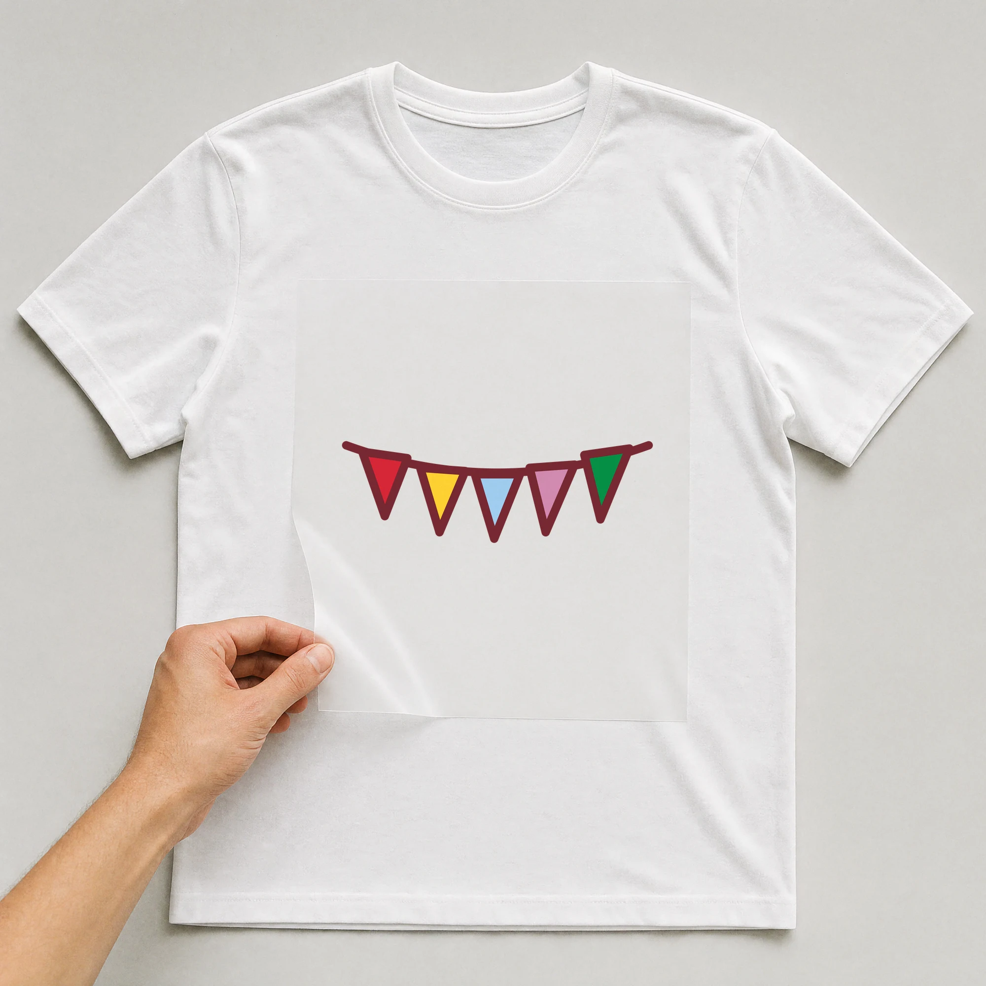Bügelbild „Wimpelkette“ auf weißem T-Shirt, Folie wird aufgelegt