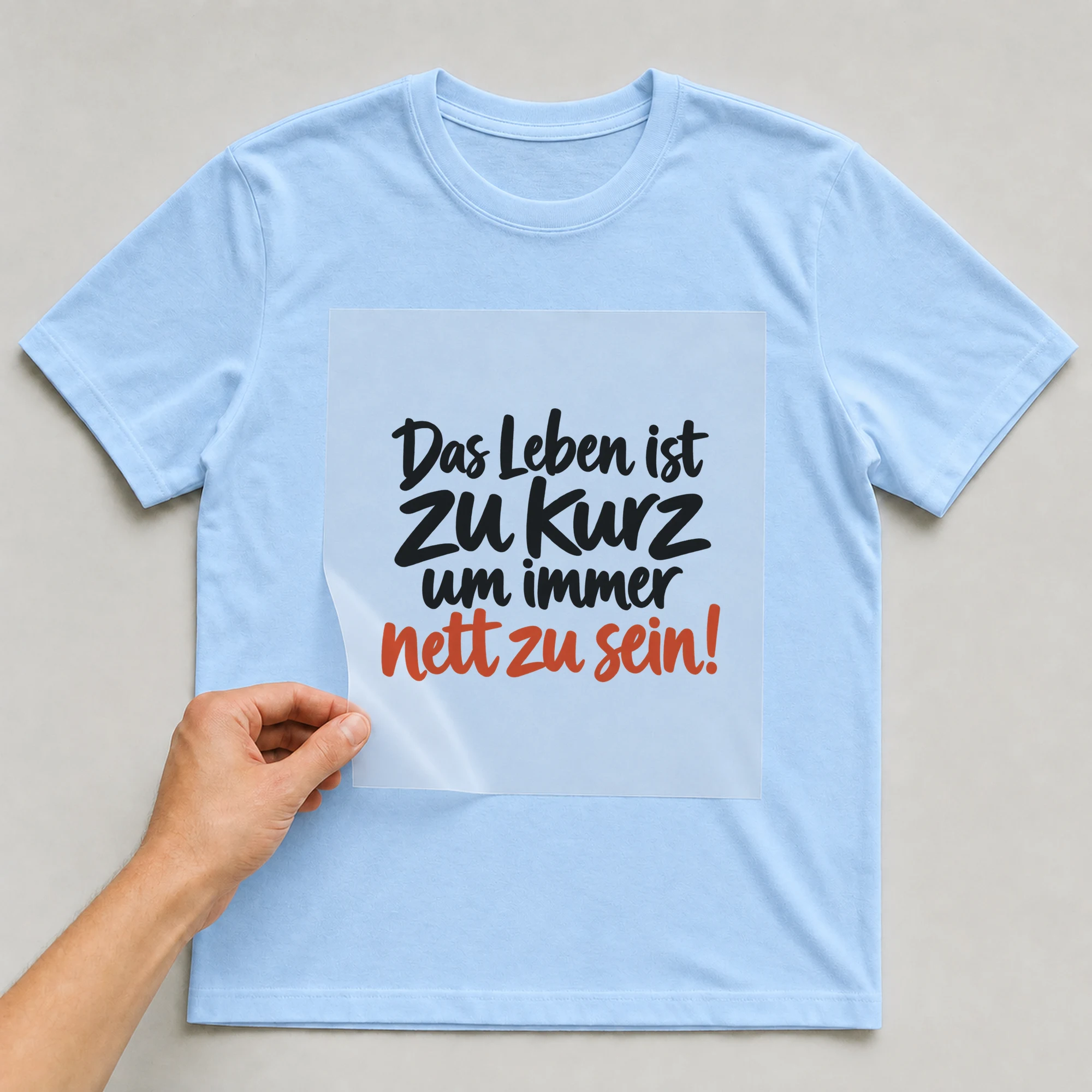 Bügelbild „Das Leben ist zu kurz um immer nett zu sein!“ auf babyblauem T-Shirt, Folie wird aufgelegt