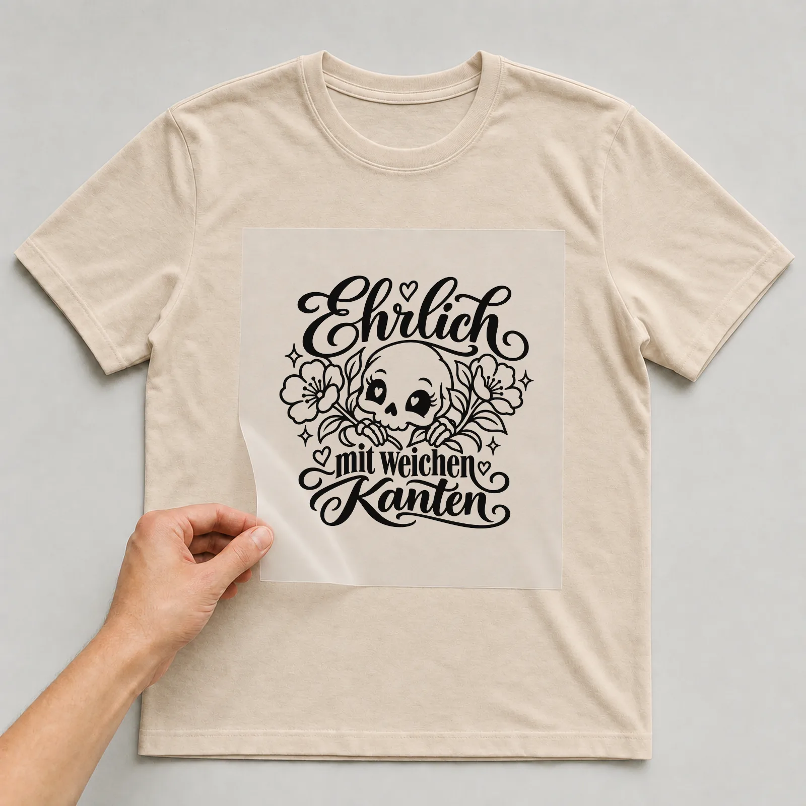 Bügelbild „Ehrlich mit weichen Kanten“ auf beigem T-Shirt, Folie wird aufgelegt