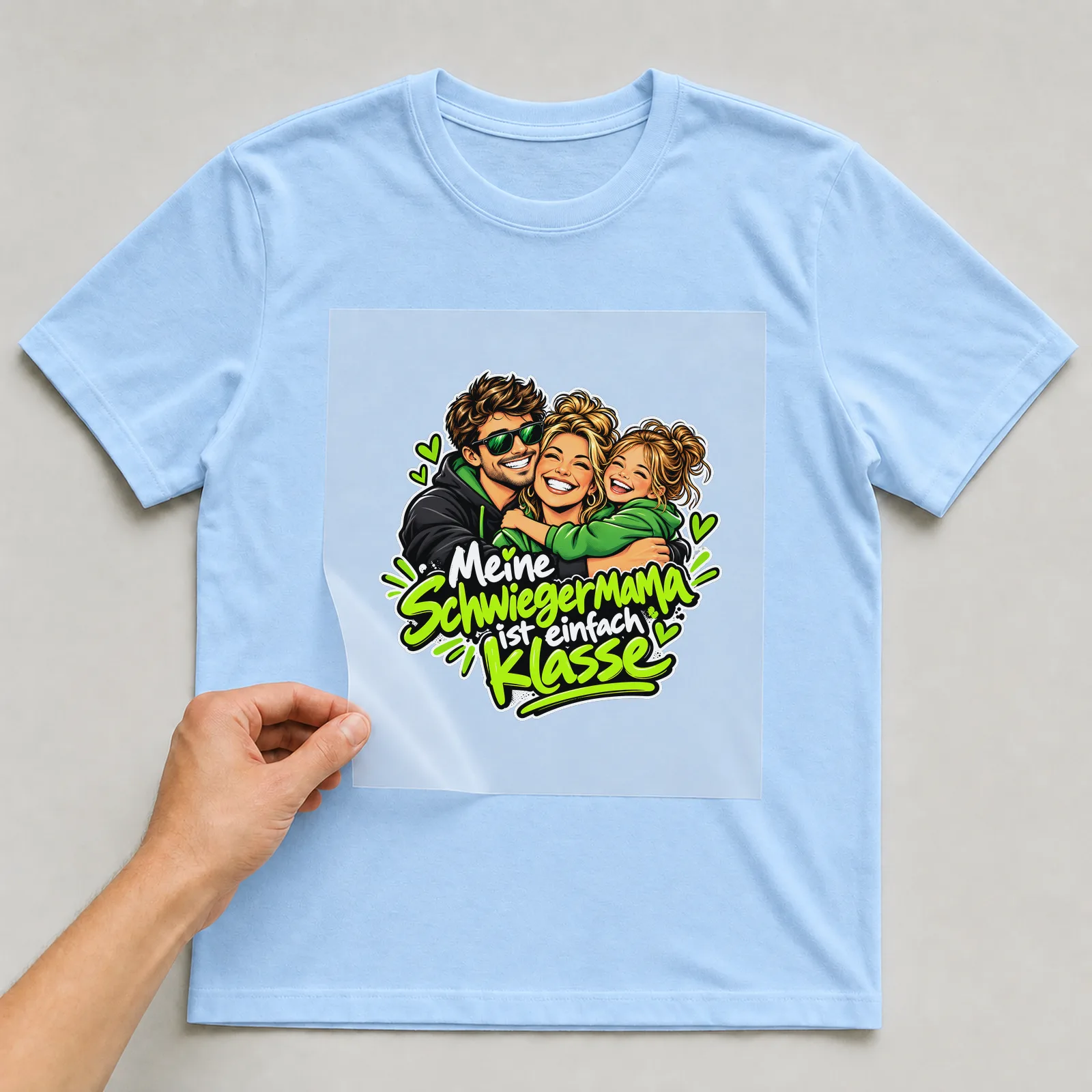 Bügelbild „Meine Schwiegermama ist einfach Klasse“ auf hellblauem T-Shirt, Folie wird aufgelegt