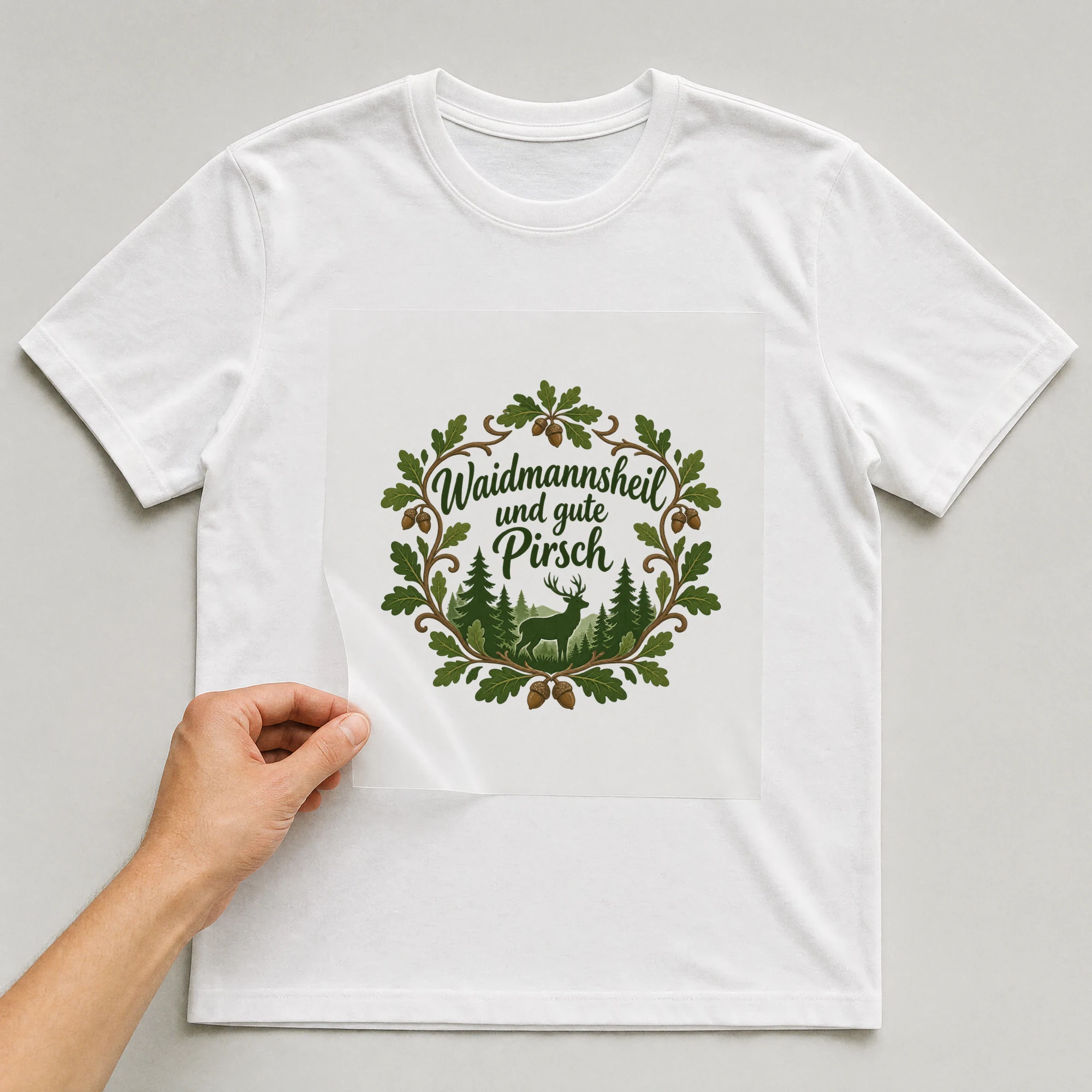 Bügelbild „Waidmannsheil und gute Pirsch“ auf weißem T-Shirt, Folie wird aufgelegt