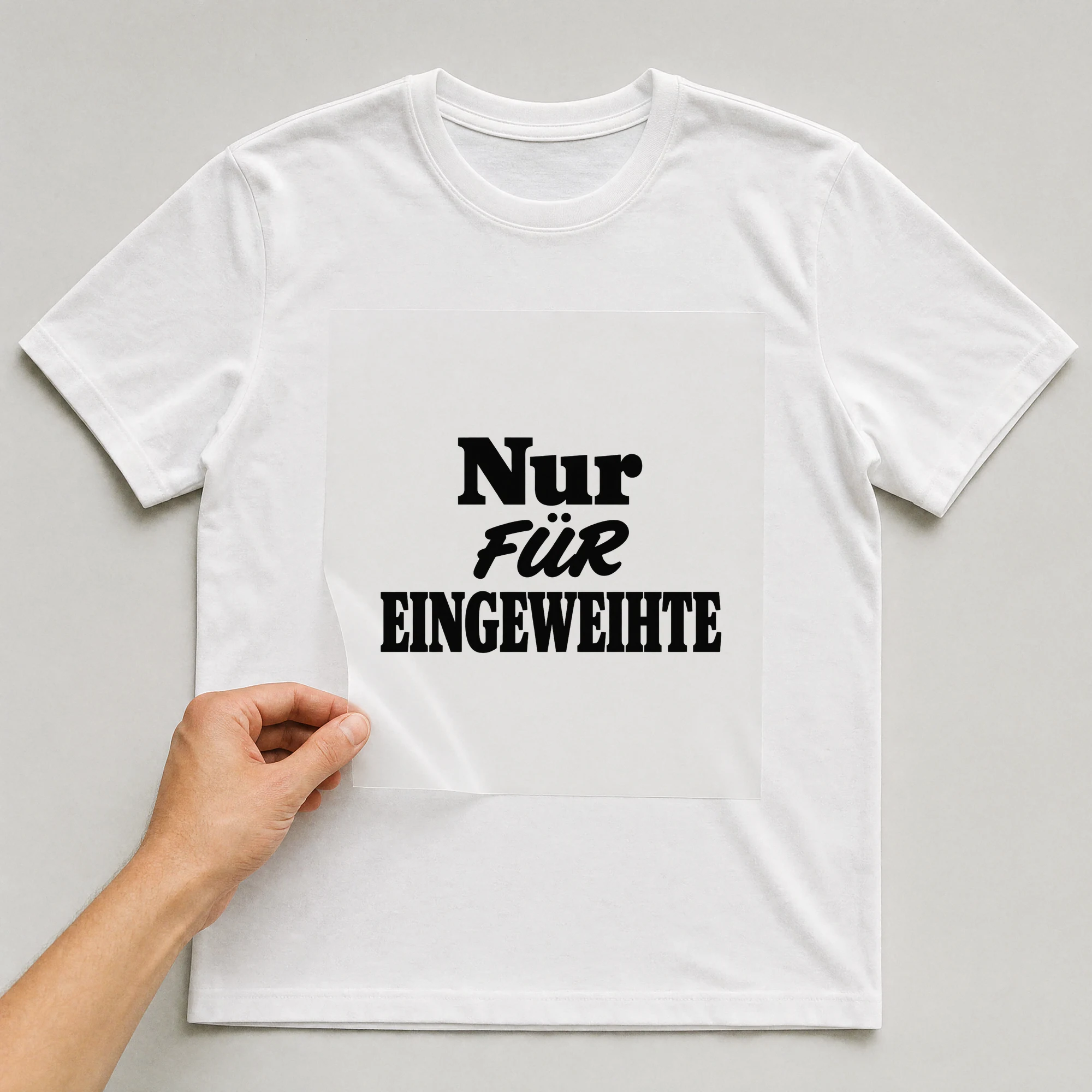 Bügelbild „Nur für Eingeweihte“ auf weißem T-Shirt, Folie wird aufgelegt