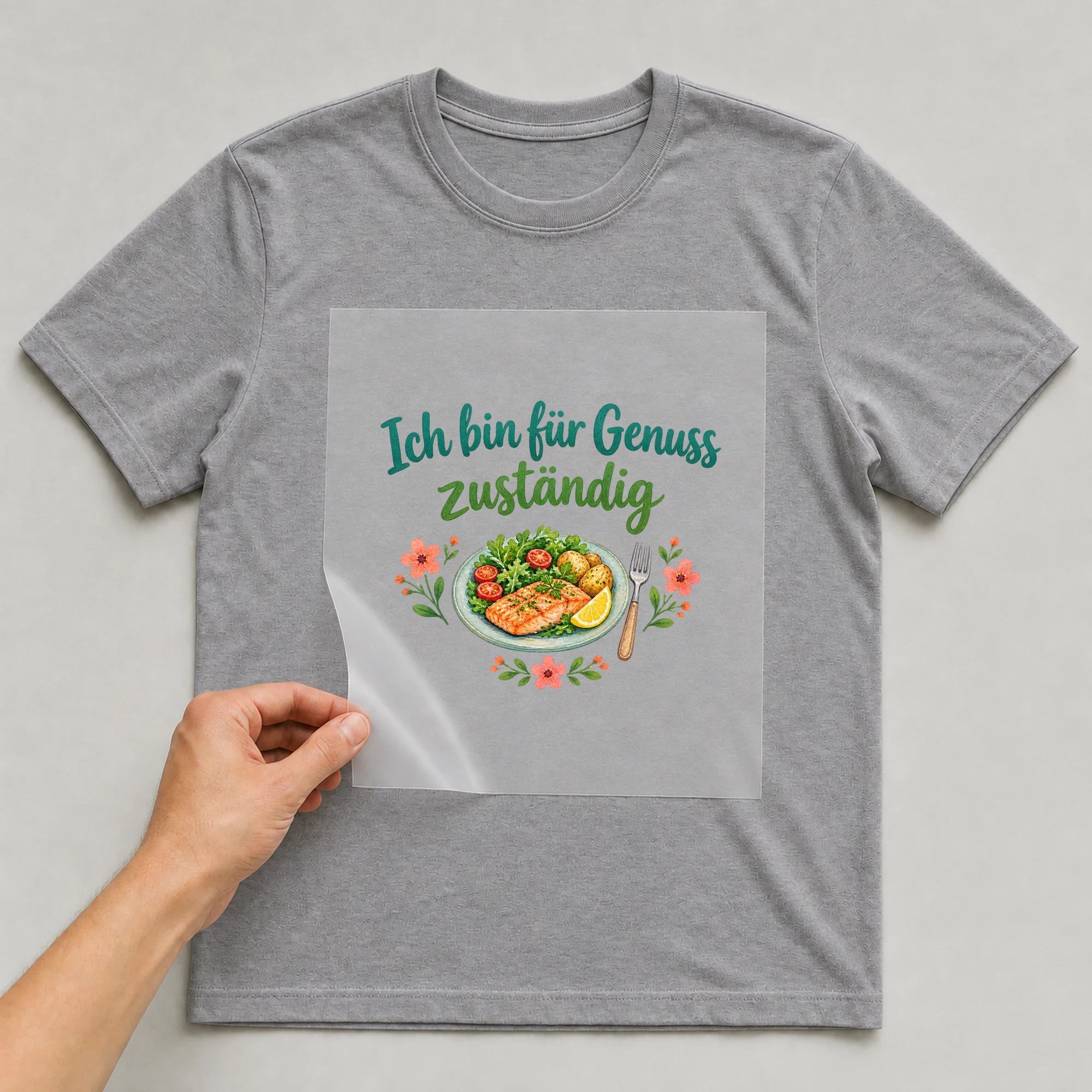 Bügelbild „Ich bin für Genuss zuständig“ auf grauem T-Shirt, Folie wird aufgelegt