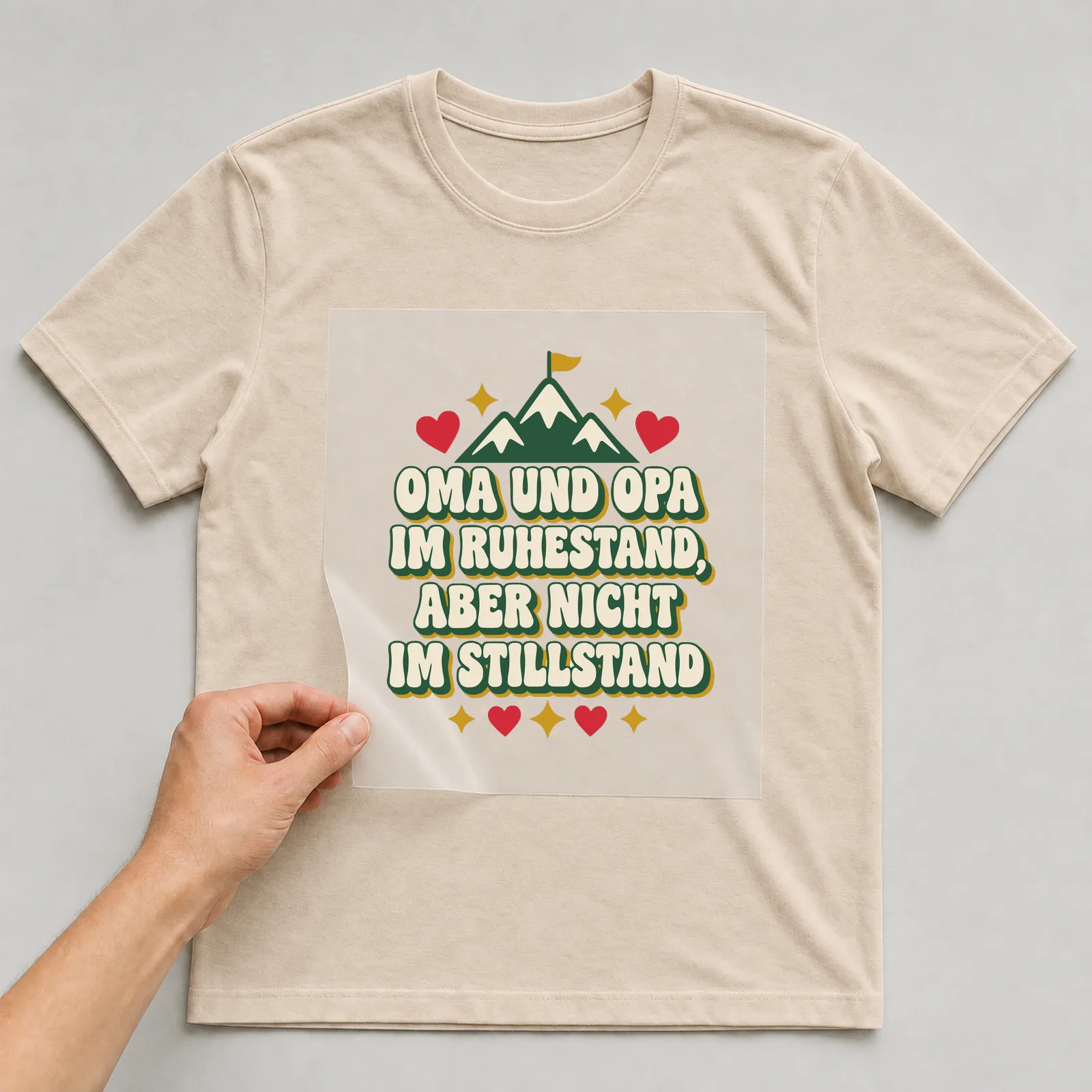 Bügelbild Oma und Opa im Ruhestand, aber nicht im Stillstand auf beigem T-Shirt, Folie wird aufgelegt