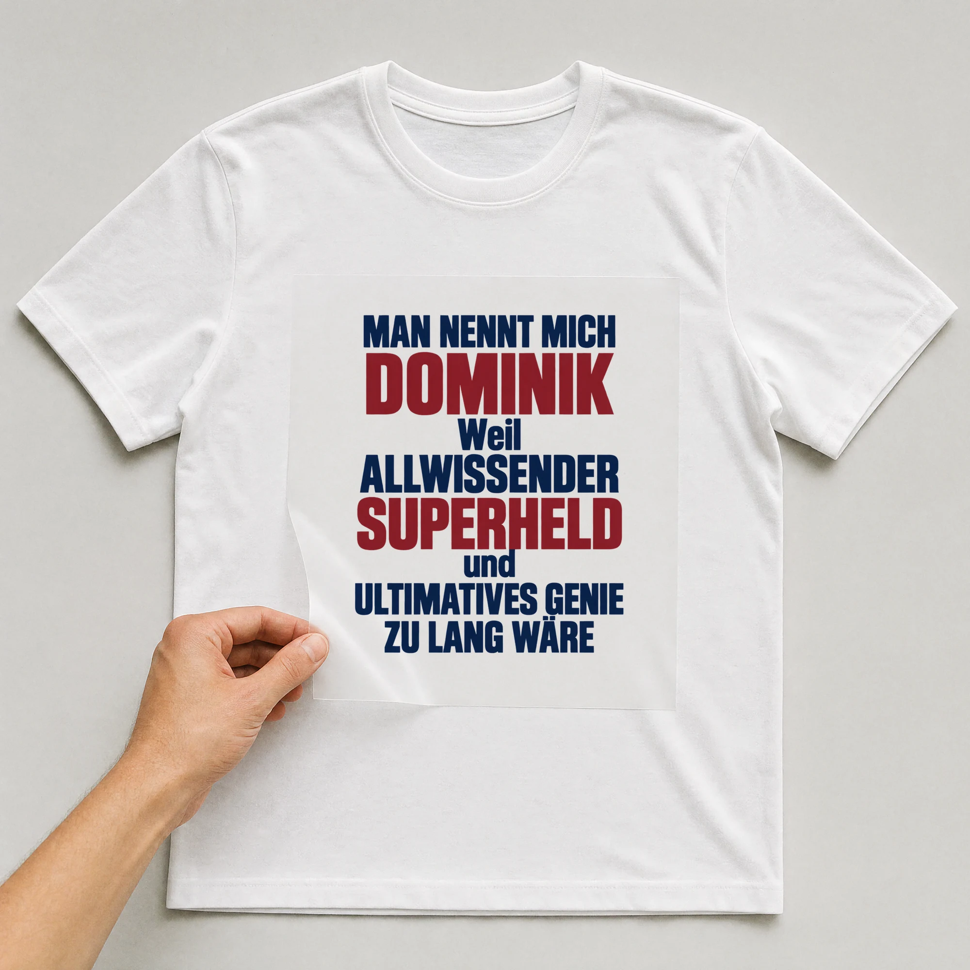 Bügelbild „Man nennt mich Dominik weil allwissender Superheld und ultimatives Genie zu“ auf weißem T-Shirt, Folie wird aufgelegt