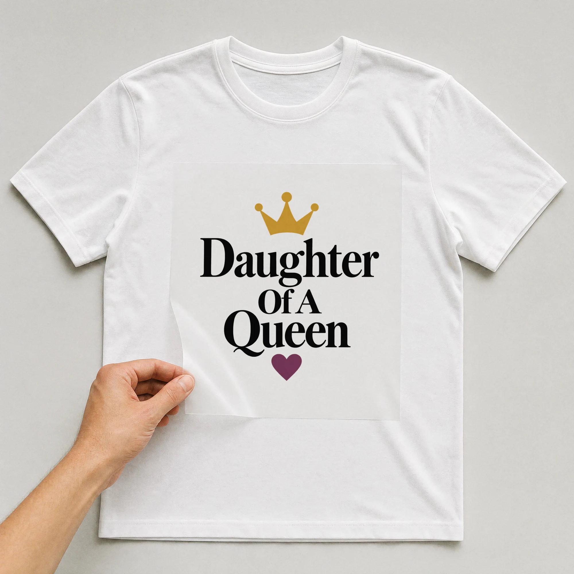 Bügelbild „Daughter Of A Queen“ auf weißem T-Shirt, Folie wird aufgelegt