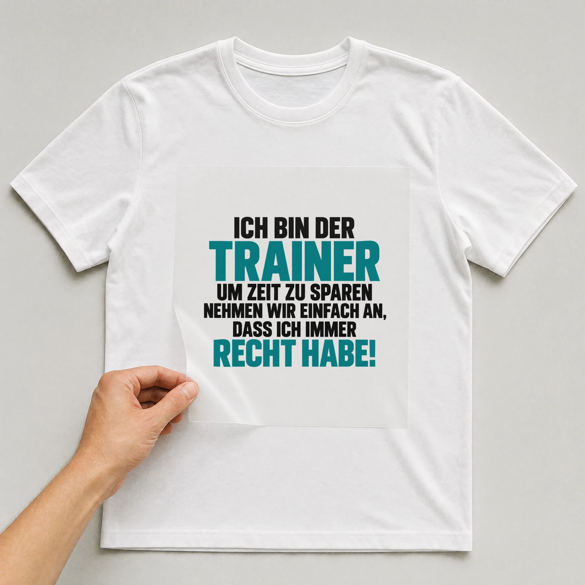Bügelbild „Ich bin der Trainer um Zeit zu sparen nehmen wir einfach an“ auf weißem T-Shirt, Folie wird aufgelegt