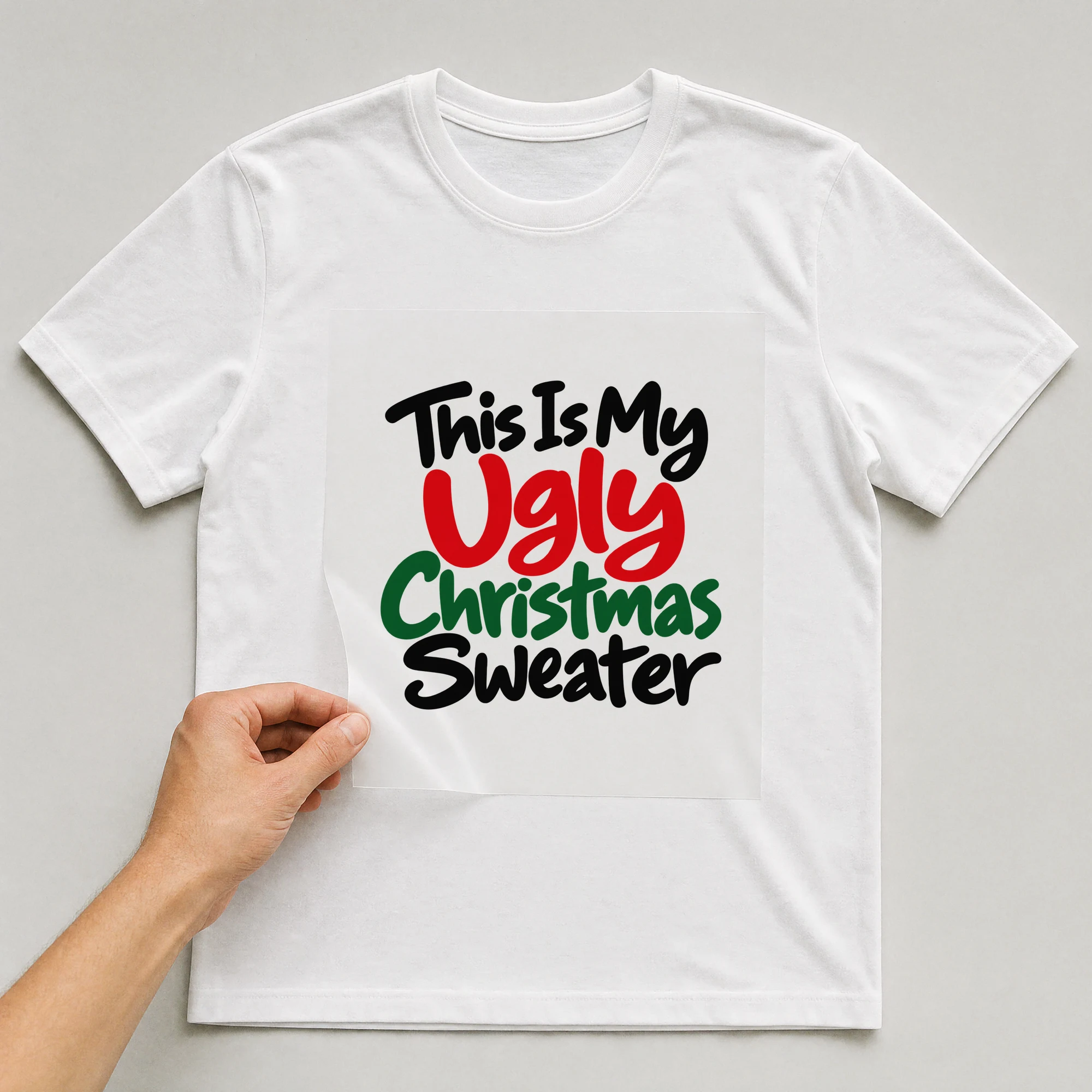 Bügelbild „This Is My Ugly Christmas Sweater“ auf weißem T-Shirt, Folie wird aufgelegt
