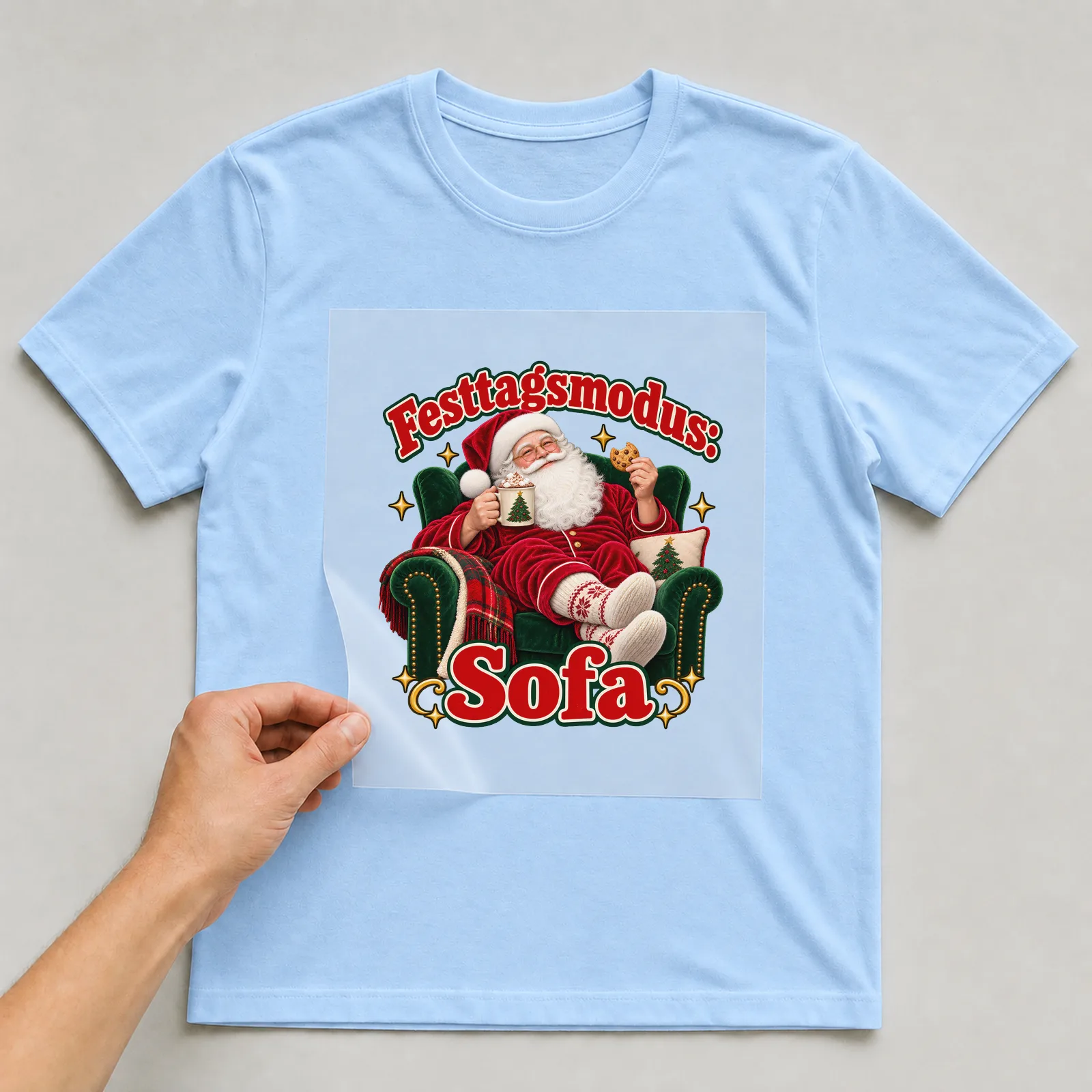 Bügelbild Festtagsmodus: Sofa (Freche Weihnachtsklassiker) auf hellblauem T-Shirt, Folie wird aufgelegt