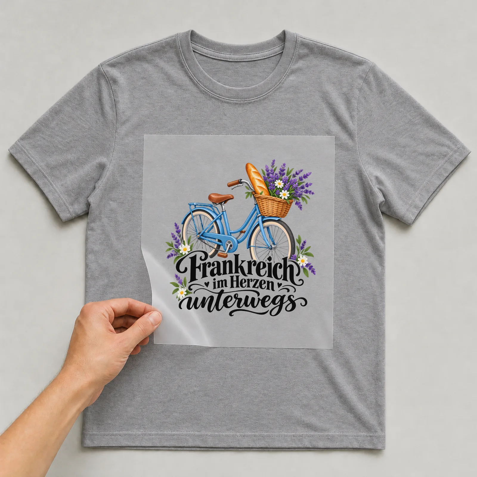 Bügelbild „Frankreich im Herzen unterwegs“ auf grauem T-Shirt, Folie wird aufgelegt